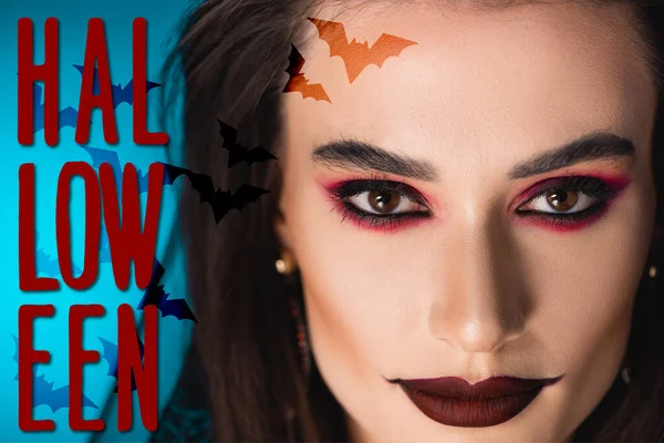 Крупный план женщины с черным макияжем, смотрящей на камеру в преддверии Хэллоуина — стоковое фото