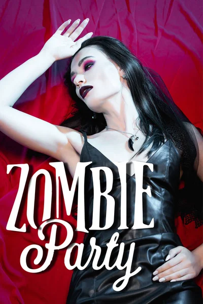 Высокий угол обзора брюнетки и бледной женщины, лежащей рядом с зомби-вечеринки буквы на красный — стоковое фото