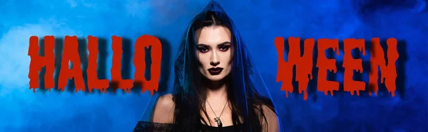 Donna in velo nero vicino scritta di Halloween su blu con fumo, banner — Foto stock