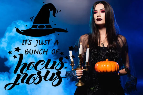 Woman in black dress and veil holding pumpkin and burning candles near it is just bunch of hocus pocus lettering on blue with smoke — Stock Photo