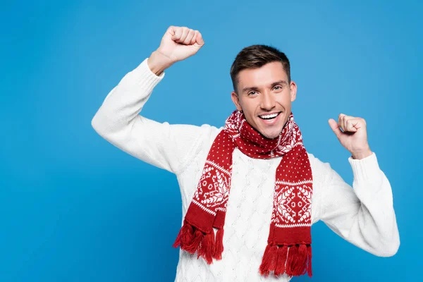 Glücklicher junger erwachsener Mann mit Händen in der Luft, der isoliert auf blauem Grund in die Kamera blickt — Stockfoto