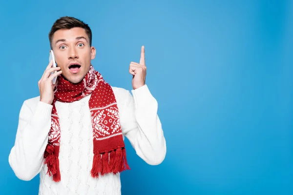 Excited young adult man with idea gesture, talking on mobile phone isolated on blue — Stock Photo