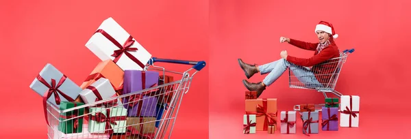 Colagem de homem em santa chapéu sentado no carrinho de compras perto de presentes no fundo vermelho, banner — Fotografia de Stock
