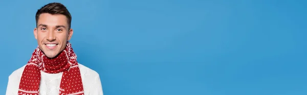 Sorrindo homem em cachecol olhando para câmera isolada em azul, banner — Fotografia de Stock