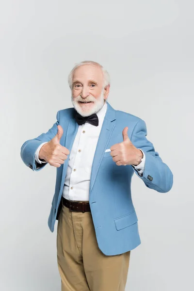 Positive senior man showing like gesture and looking at camera isolated on grey — Stock Photo