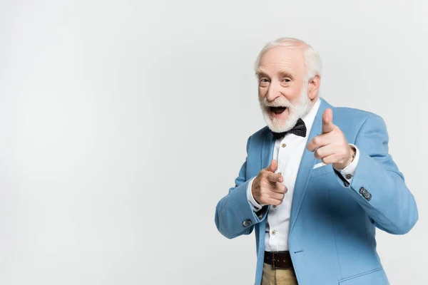 Excited senior man in bow tie pointing with fingers at camera isolated on grey — Stock Photo