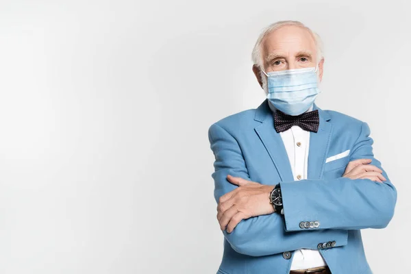 Старший в медицинской маске, галстуке-бабочке и пиджаке смотрит на камеру, изолированную на сером — стоковое фото