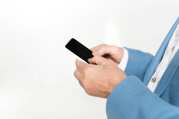 Vue recadrée de l'homme âgé à l'aide d'un smartphone avec écran blanc isolé sur gris — Photo de stock