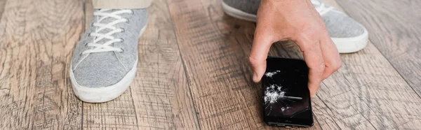 Vista cortada do homem tomando smartphone esmagado do chão, banner — Fotografia de Stock