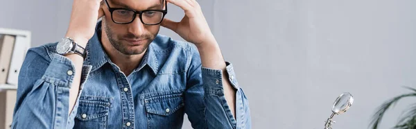 Exhausted repairman with hands near head on blurred background, banner — Stock Photo