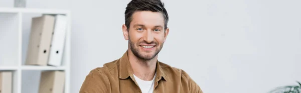 Happy businessman looking at camera on blurred background, banner — Stock Photo