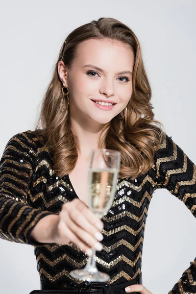 Fröhliche Frau mit einem Glas Champagner im verschwommenen Vordergrund — Stockfoto