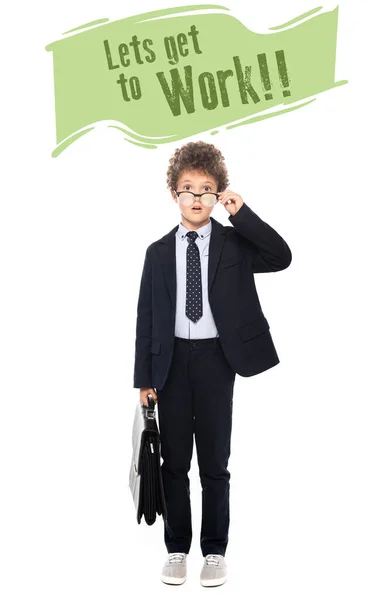 Chico sorprendido en traje la fijación de gafas y la celebración de maletín cerca permite ponerse a trabajar letras en blanco - foto de stock