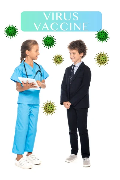 Child in costume of doctor holding digital tablet near curly boy in formal wear and virus vaccine lettering on white — Stock Photo