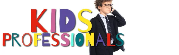 Curly boy in suit and glasses talking on smartphone near kids professionals lettering on white, banner — Stock Photo