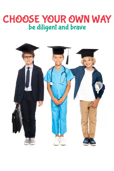 Enfants en casquettes de graduation vêtus de costumes de différentes professions debout près de choisir votre propre façon être diligent et courageux lettrage sur blanc — Photo de stock