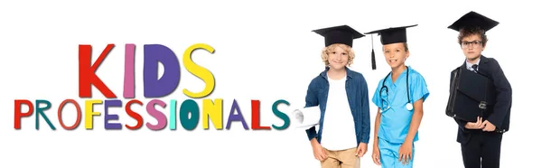 Bambini in berretti di laurea vestiti in costumi di diverse professioni vicino a bambini professionisti lettering su bianco, banner — Foto stock