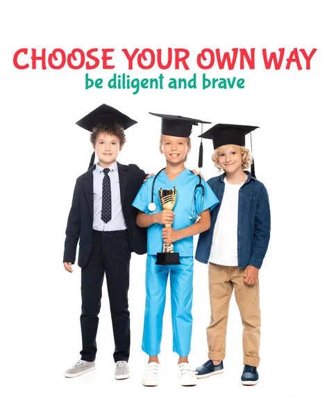 Niños en gorras de graduación vestidos con disfraces de diferentes profesiones con trofeo de oro cerca de elegir su propio camino ser diligente y valiente letras en blanco - foto de stock