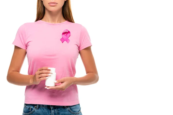 Cropped view of young woman with breast cancer awareness ruban holding jar with pills isolated on white — Photo de stock