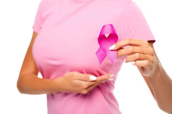 Vista recortada de la mujer que sostiene la cinta de la conciencia del cáncer de mama y tocar el pecho sobre fondo borroso aislado en blanco - foto de stock