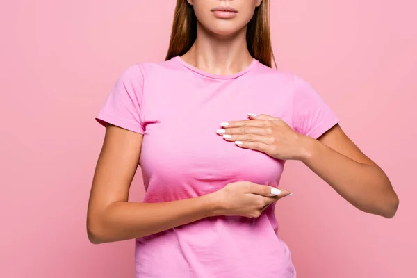 Ausgeschnittene Ansicht einer Frau im rosa T-Shirt, die ihre Brust isoliert auf rosa berührt — Stockfoto