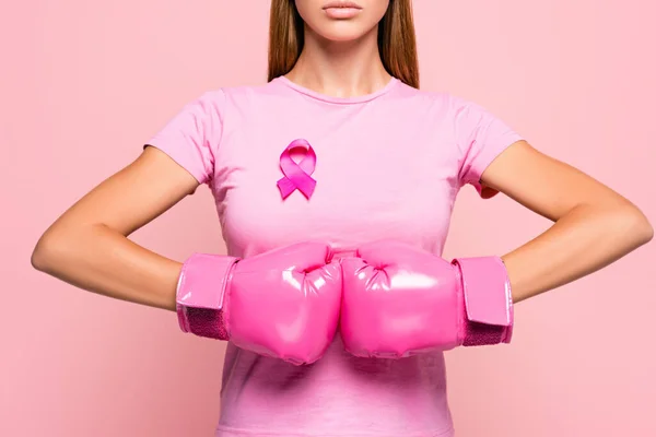 Vista parcial da mulher em luvas de boxe vestindo sinal de consciência de câncer de mama isolado em rosa — Fotografia de Stock