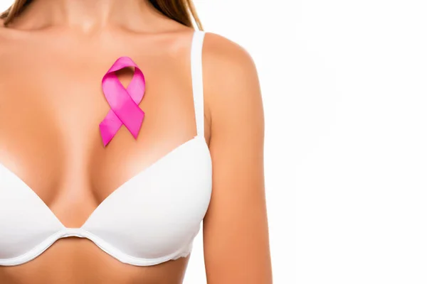 Vue recadrée du signe rose de sensibilisation au cancer du sein sur la poitrine de la femme en soutien-gorge isolé sur blanc — Photo de stock