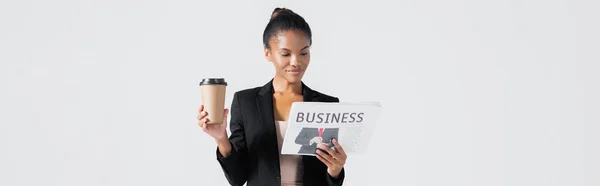 African american businesswoman with business newspaper and coffee to go isolated on grey, banner — Stock Photo