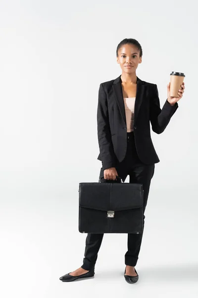 Африканская американская бизнесвумен с чемоданом и бумажной чашкой изолированы на белом — стоковое фото