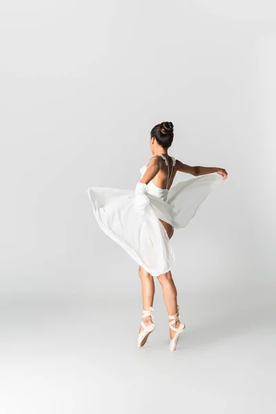 Anmutige afrikanisch-amerikanische Ballerina im Kleid, das auf weißem Hintergrund tanzt — Stockfoto