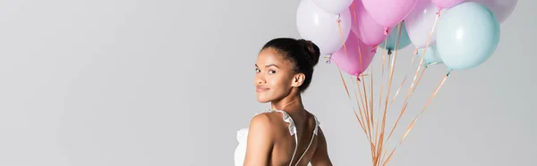 Anmutige afrikanisch-amerikanische Ballerina im Kleid, das mit Luftballons auf weißem Hintergrund tanzt, Banner — Stockfoto