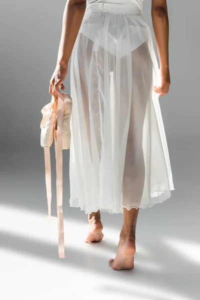 Cropped view of graceful african american ballerina with pointe shoes on white background — Stock Photo