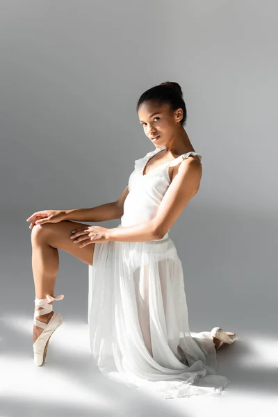 Elegante bailarina afroamericana en vestido sobre fondo blanco - foto de stock