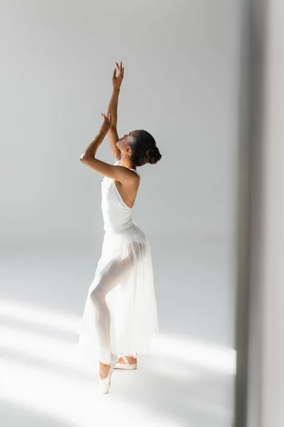 Graciosa bailarina americana africana no vestido dançando no fundo branco — Fotografia de Stock