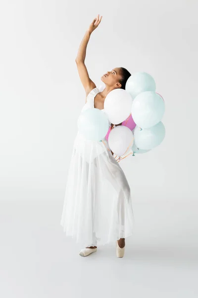 Elegante bailarina afroamericana con globos aislados en blanco - foto de stock