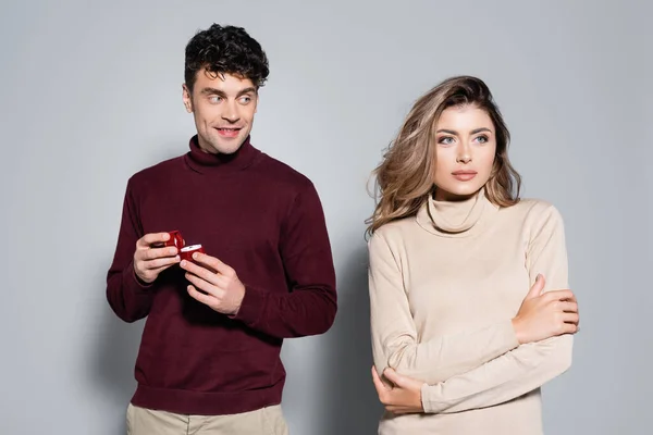 Casual jeune homme avec bague de fiançailles près de femme isolé sur gris — Photo de stock