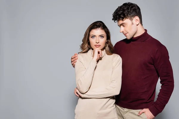 Casal jovem casual em jumpers posando isolado no cinza — Fotografia de Stock