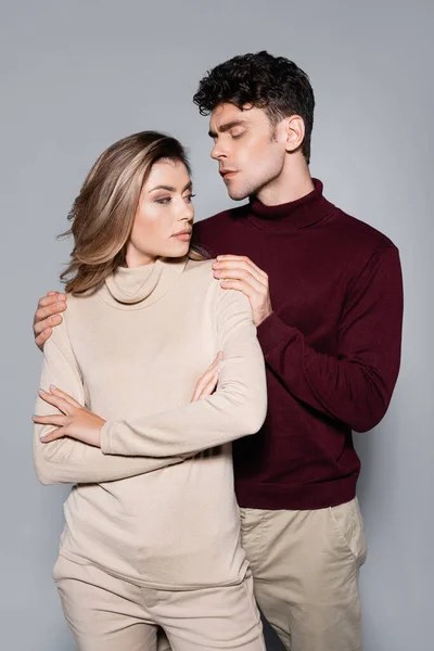 Casual jeune couple en pulls posant isolé sur gris — Photo de stock