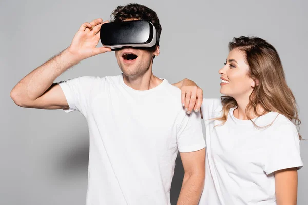 Choqué homme dans vr casque près de femme isolé sur gris — Photo de stock