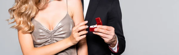 Vista recortada de un joven elegante haciendo propuesta de matrimonio aislado en gris, pancarta - foto de stock