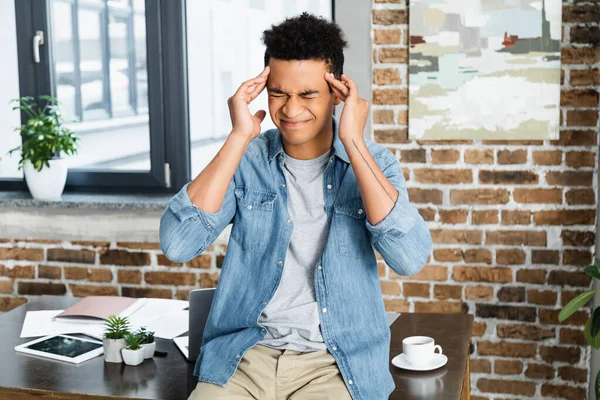 Homme afro-américain aux yeux fermés souffrant de migraine — Photo de stock
