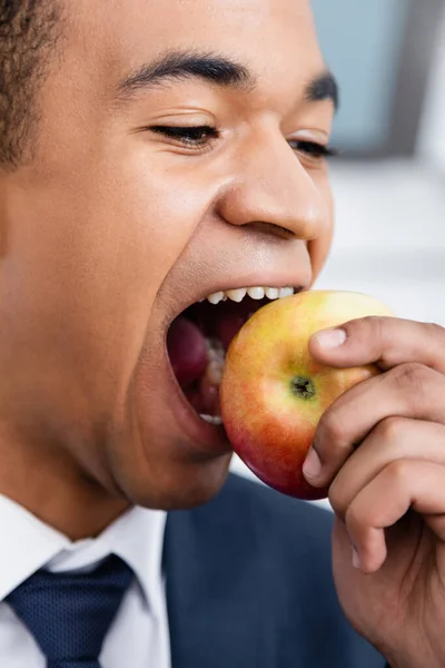 Africano americano empresário mordendo maçã — Fotografia de Stock
