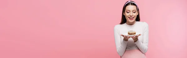 Happy young pretty pregnant woman with cake isolated on pink, banner — Stock Photo