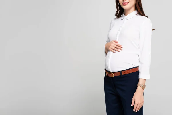 Обрезанный взгляд на молодую беременную деловую женщину, изолированную на сером — стоковое фото