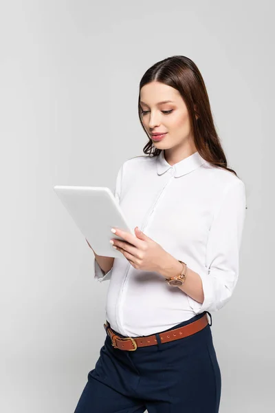 Молода вагітна бізнес-леді з цифровим планшетом ізольована на сірому — стокове фото