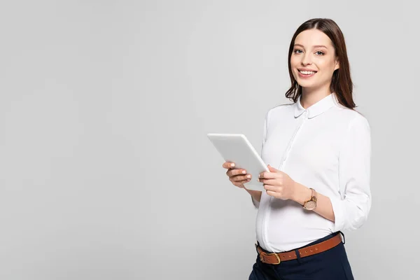 Jeune femme d'affaires enceinte souriante avec tablette numérique isolée sur gris — Photo de stock