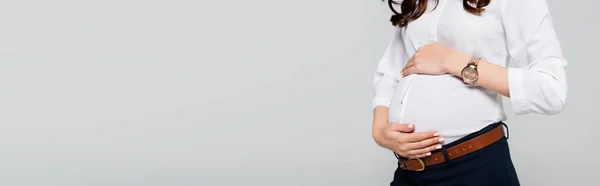 Vista ritagliata della giovane donna d'affari incinta che tocca la pancia isolata sul grigio, banner — Foto stock