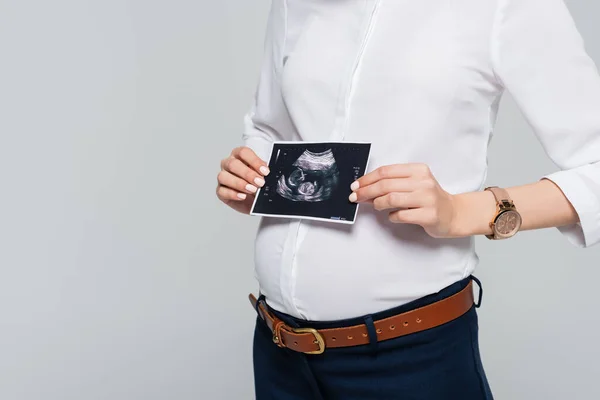 Обрізаний вид молодої вагітної бізнес-леді, що тримає ультразвукове сканування ізольовано на сірому — стокове фото