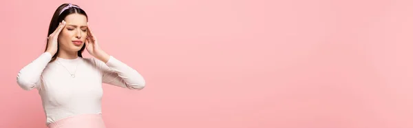 Jovem mulher grávida bonita que sofre de dor de cabeça isolada em rosa, banner — Fotografia de Stock