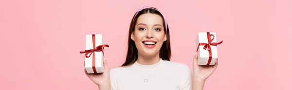 Happy young pretty woman with gifts isolated on pink, banner — Stock Photo